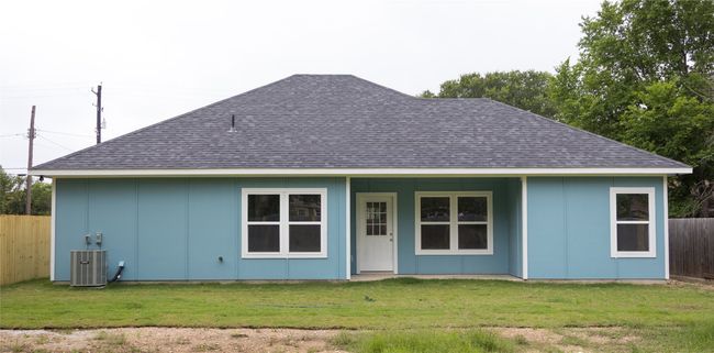 Back of property featuring a shingled roof, central air condition unit, and board and batten siding | Image 11