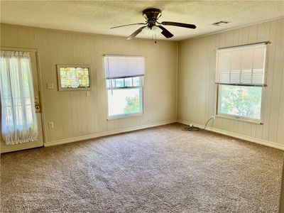 Living room with carpet floors, a textured ceiling, and ceiling fan | Image 2