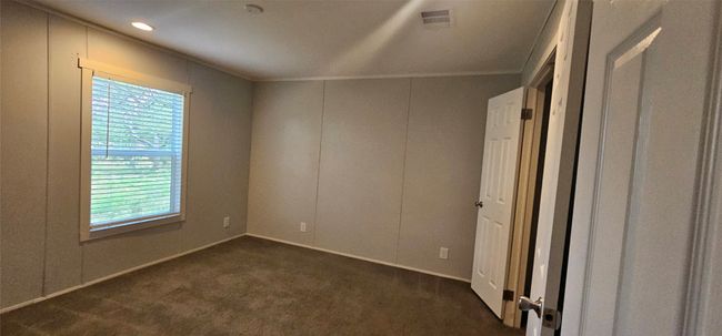 Unfurnished room featuring dark carpet and crown molding | Image 9