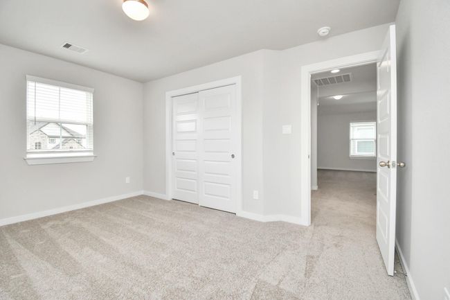 Generously sized secondary bedrooms featuring spacious closets, soft and inviting carpeting underfoot, large windows allowing plenty of natural light, and the added touch of privacy blinds for your personal retreat. | Image 33