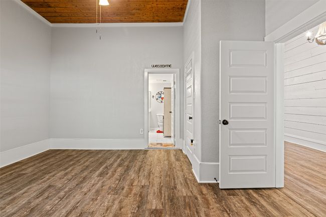 Spare room featuring baseboards, wooden ceiling, wood finished floors, and a chandelier | Image 25