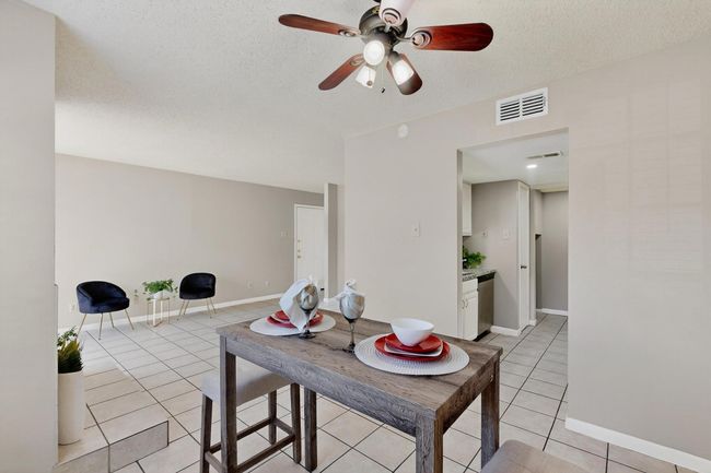 Dining space with a textured ceiling, ceiling fan, and light tile patterned floors | Image 16