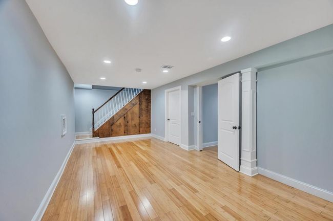Finished below grade area with visible vents, light wood-style flooring, baseboards, stairway, and recessed lighting | Image 21
