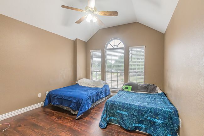 Bedroom with wood finished floors, vaulted ceiling, and a ceiling fan | Image 32