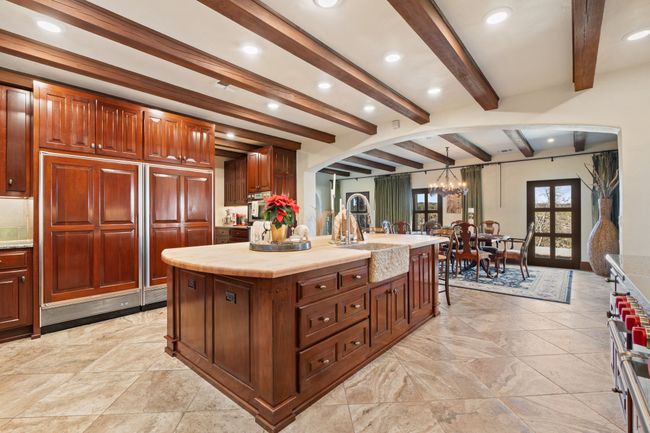 Kitchen featuring a sink, light countertops, beamed ceiling, and a kitchen island | Image 10