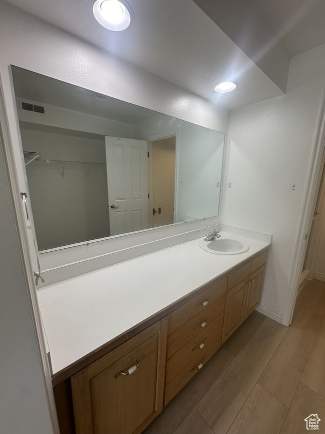 Bathroom with vanity, wood finished floors, and a walk in closet | Image 8