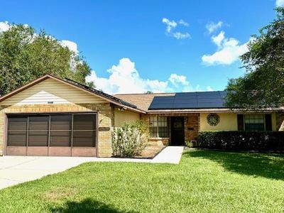 Front of home with solar panels, and concrete walkway up to front door | Image 1