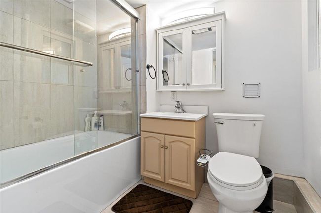 Bathroom featuring vanity, toilet, and combined bath / shower with glass door | Image 31