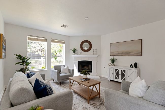 Living room featuring wood finished floors and a fireplace with raised hearth | Image 11