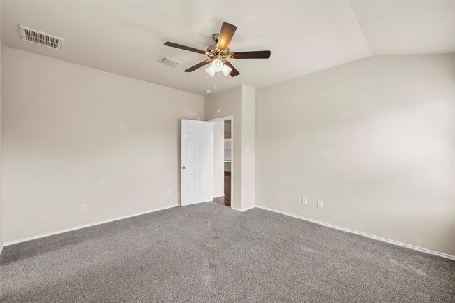 Carpeted empty room with ceiling fan and vaulted ceiling | Image 19