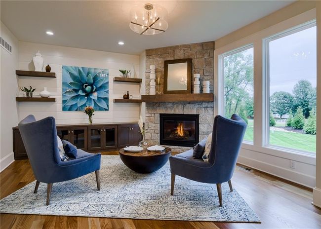 Sitting room featuring hardwood / wood-style flooring, an inviting chandelier, and a fireplace | Image 11