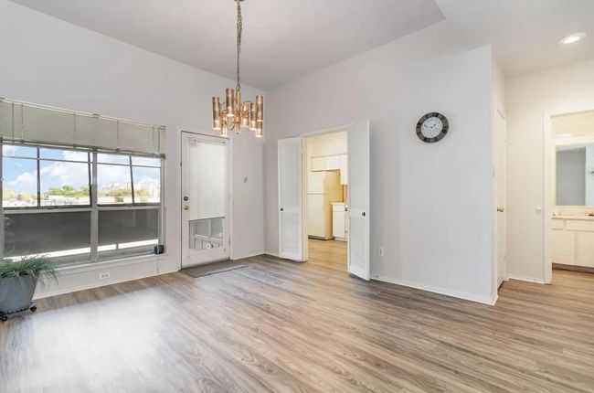 Unfurnished dining area with wood finished floors, a chandelier, baseboards, and recessed lighting | Image 9