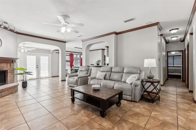 Living room with arched walkways, visible vents, and a ceiling fan | Image 15