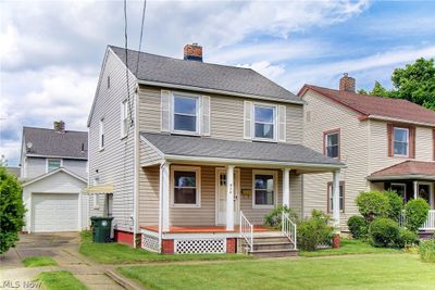 View of front of property with a front yard, a garage, and a porch | Image 1