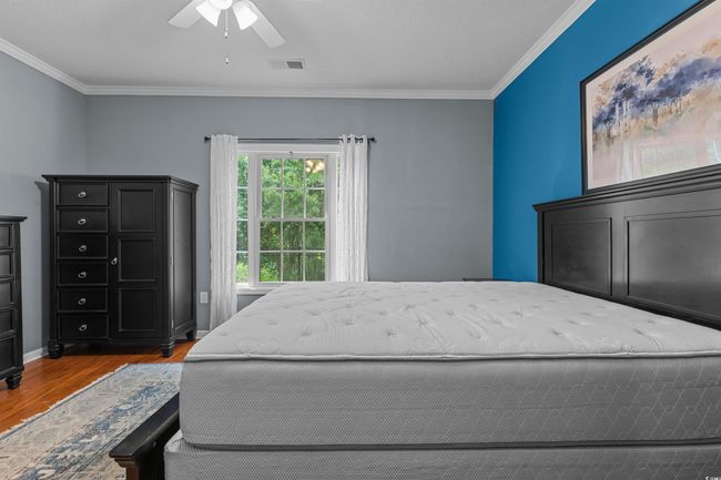 Bedroom featuring wood finished floors, crown molding, and ceiling fan | Image 24
