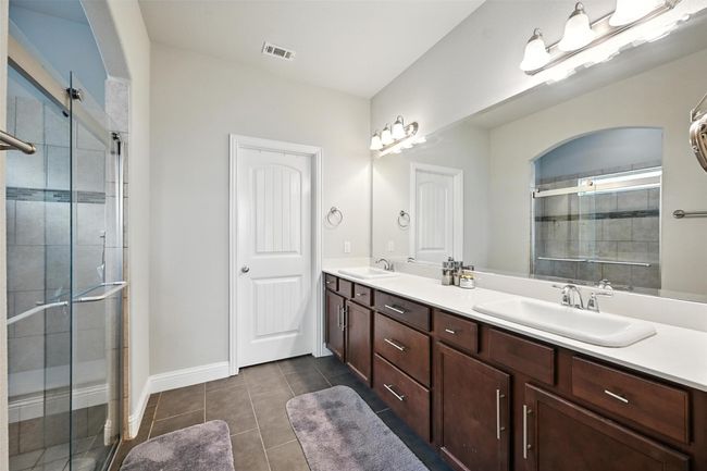 Primary Bathroom featuring double vanity, a stall shower, and tile patterned flooring | Image 17