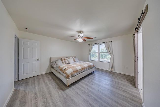 Spacious primary bedroom offers comfort and relaxation with ample natural light and room for a cozy sitting area. | Image 23