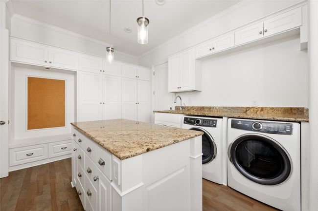 Washroom featuring independent washer and dryer, dark wood-style floors, and ornamental molding | Image 17