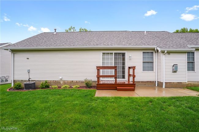 Rear view of property with roof with shingles, a yard, a patio, and central air condition unit | Image 23