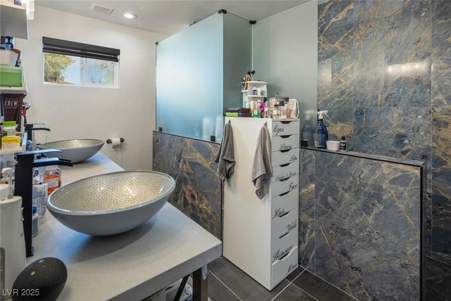 Bathroom featuring tile patterned flooring, visible vents, tile walls, and a sink | Image 21