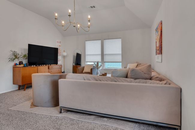 Living area with vaulted ceiling, a chandelier, and carpet floors | Image 18