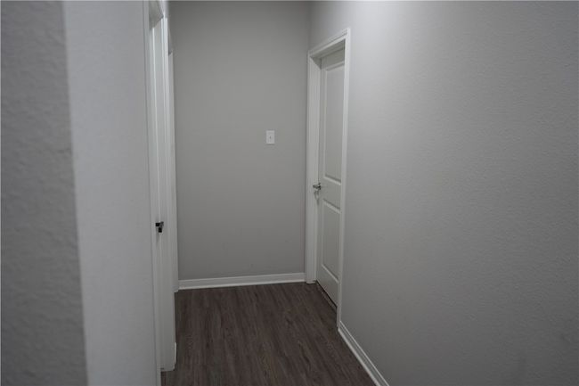 Corridor with dark wood-type flooring and baseboards | Image 11