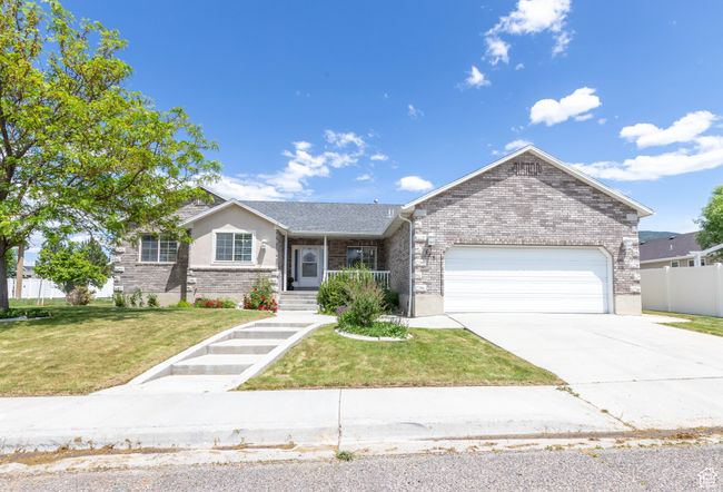 Single story home with brick siding, a garage, and concrete driveway | Image 21
