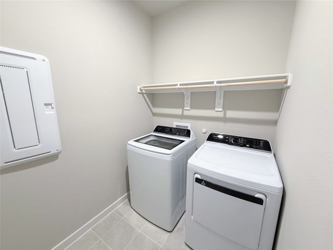Laundry room featuring washing machine and dryer, baseboards, and light tile patterned floors | Image 31