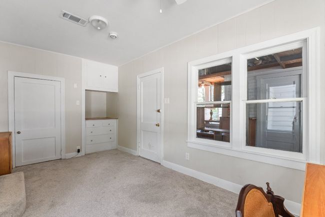 View of closet and built in dressers in third bedroom. Windows overlook workshop. | Image 24