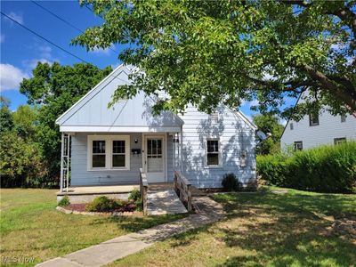 View of front of home with covered porch and a front lawn | Image 1