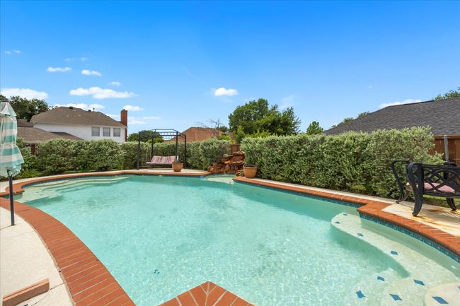 View of swimming pool with a fenced backyard | Image 33