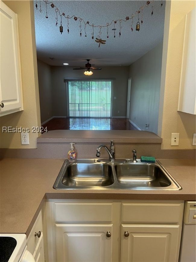 Kitchen featuring white cabinetry, sink, ceiling fan, and a textured ceiling | Image 12