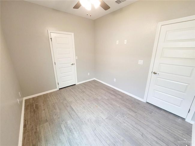 Empty room with visible vents, baseboards, a ceiling fan, and wood finished floors | Image 11