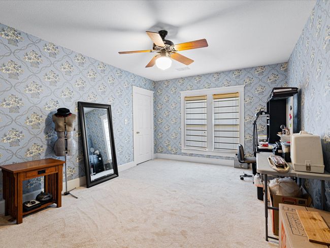 Office with visible vents, carpet, wallpapered walls, baseboards, and ceiling fan | Image 28