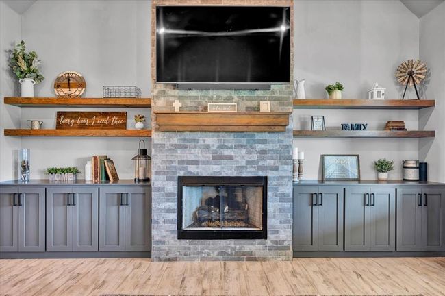Living area with a fireplace and wood finished floors | Image 17