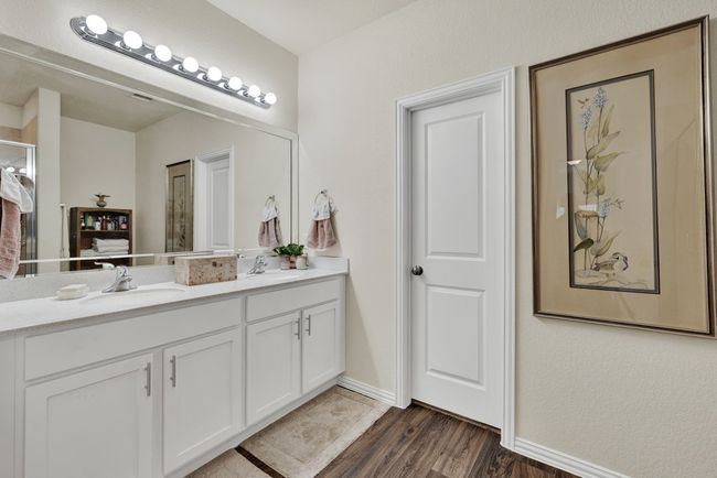 Bathroom featuring double vanity, baseboards, a sink, and wood finished floors | Image 19