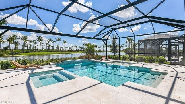 View of swimming pool with a pool with connected hot tub, a patio, a water view, and a lanai | Image 16