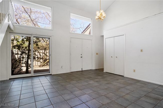 Foyer entrance with baseboards, a high ceiling, tile patterned flooring, and a notable chandelier | Image 41