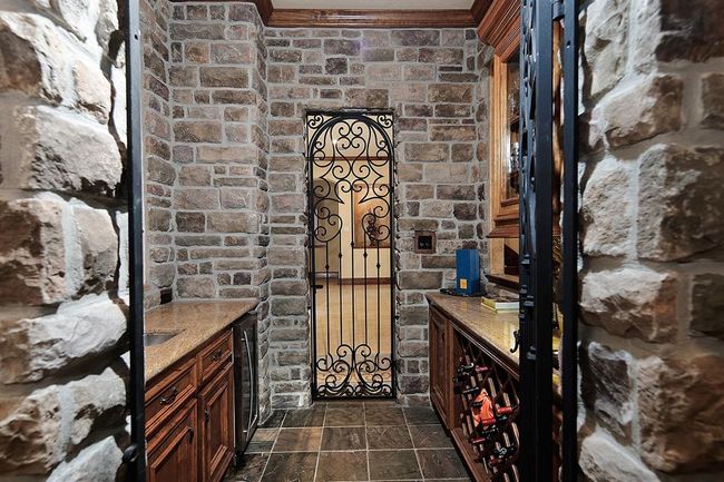 Wine grotto highlights rustic stone walls, rich wood cabinetry and combines charm and functionality | Image 8