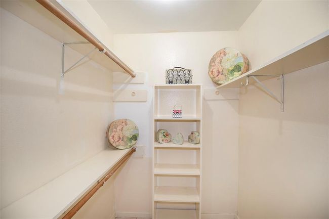 A spacious walk-in closet provides ample storage for clothing and accessories, keeping everything neatly organized. | Image 26