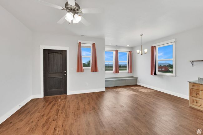Unfurnished living room with a chandelier, wood finished floors, ceiling fan, and recessed lighting | Image 45