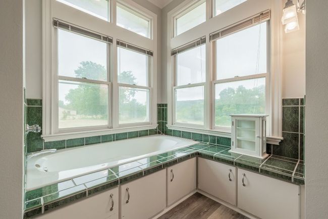 Bathroom featuring plenty of natural light, a Jacuzzi bath, and wood floors | Image 24
