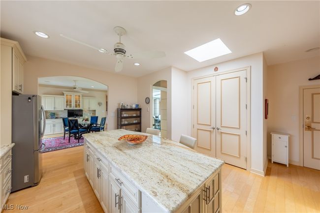 Kitchen with skylight, features granite countertops, large center island, plentiful cabinet space, pantry, stainless steel appliances, high ceilings and private catering entrance. | Image 11