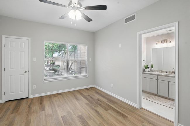 Unfurnished bedroom featuring a sink, light wood-type flooring, baseboards, visible vents, and connected bathroom | Image 11