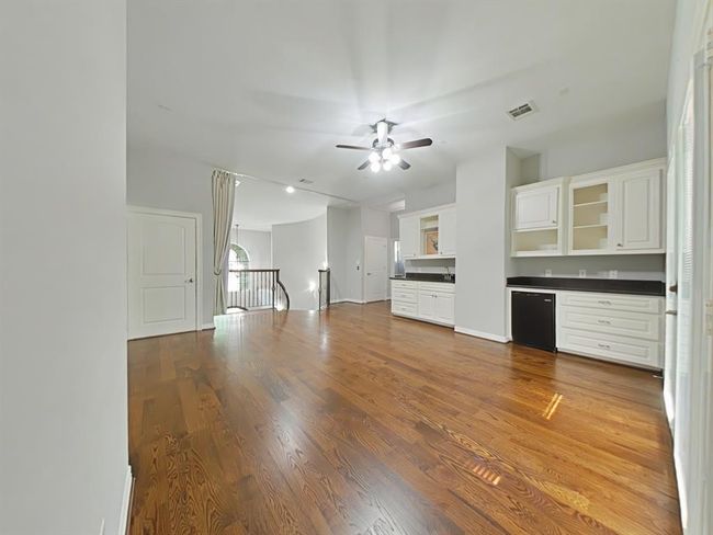 Elevate your entertainment experience in this stylish media room featuring a wet bar, beverage fridge, and French doors opening to the upper porch. | Image 24