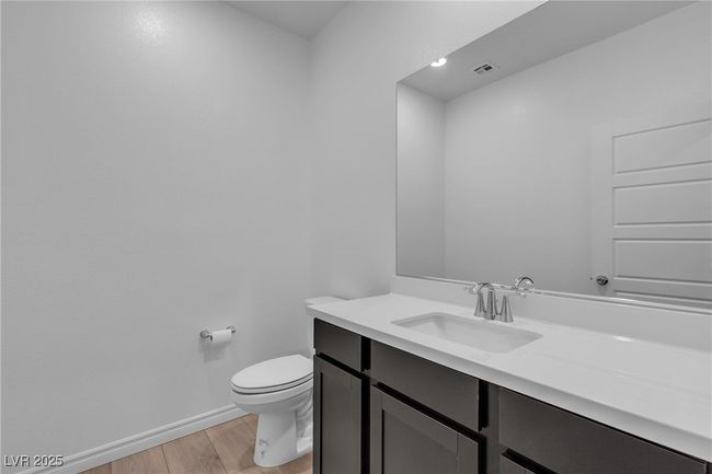 Half bath featuring vanity, wood finished floors, toilet, and baseboards | Image 12