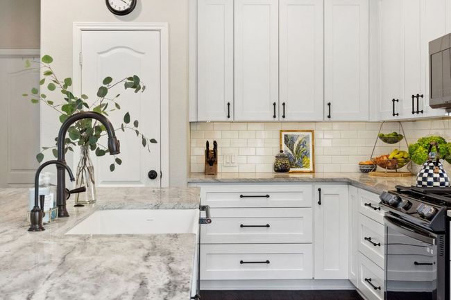 Featuring ample counter space and cabinetry storage plus a pantry. | Image 10