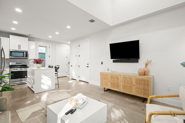Living room with recessed lighting and finished concrete floors | Image 9