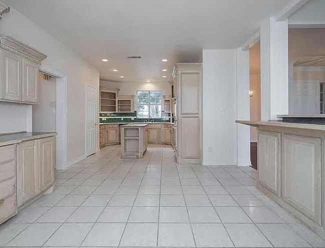 Kitchen with light tile patterned floors, recessed lighting, light countertops, a kitchen island, and open shelves | Image 8
