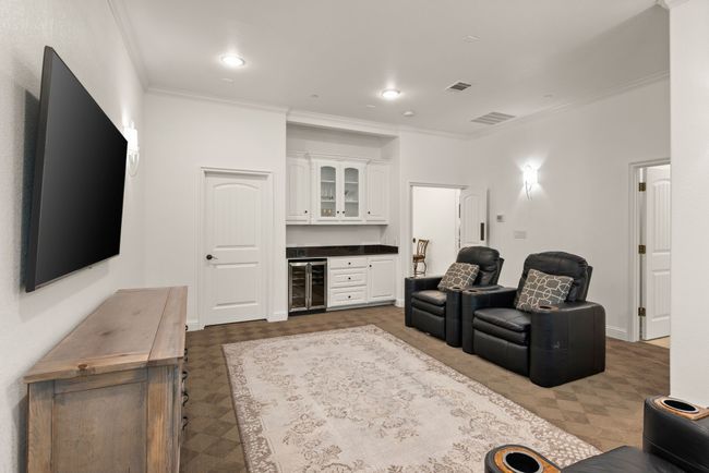 Another view of the upstairs living area. It features a granite topped dry bar with a beverage cooler, storage closet, and patterned carpet. | Image 25